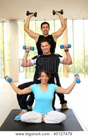 Gruppe, die mit Hanteln im Fitnessstudio