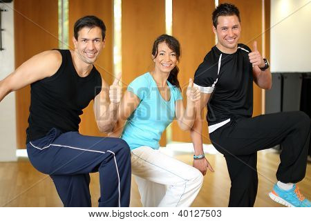 Drei Leute, die In einem Fitnessstudio Aerobic