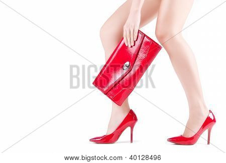 schÃ¶ne schlanke weibische FÃ¼ÃŸe rote Schuhe und Mini-Beutel