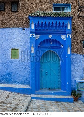 Chefchaouen, Morocco - 20 October, 2019: Traditional Blue Door And Zaouia Raysoni Label On Wall In M