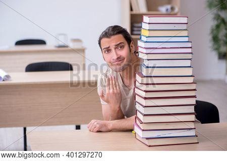 Young male student preparing for exams at library