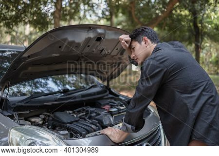 Man' Hand Open Hood Of A Broken Car And Wipe The Sweat On The Road In The Forest. Car Breakdown Conc