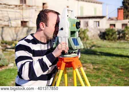 Man Using Of Total Station. Guy Surveyor At Work. Survey Instrument Geodetic Device, Total Station S