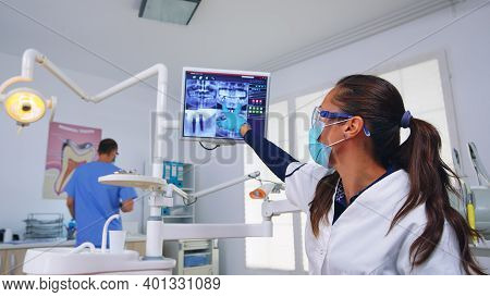 Patient Pov To Dentist Talking About Mouth Hygine Showing X-ray On Monitor. Stomatology Specialist W