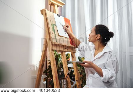 A Cute Brunette Handing A Box With Pencils And Drawing At Home.