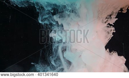 Splash Of Colored Ink In Water On Black Background. Action. Two Colors Are Mixed In Water On Isolate