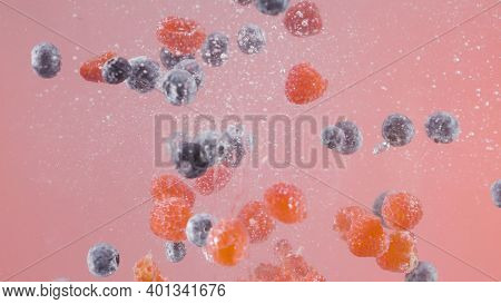 Berries Fall Into Water On Isolated Background. Action. Juicy Berries Fall Into Water With Bubbles. 