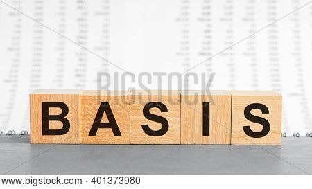 Basis Word Written On Wood Block On The Background Of Columns Of Numbers. Basis Text On Wooden Table