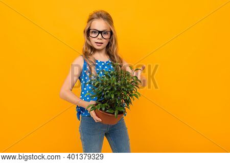 Portrait Of Young Caucaian Girl With Long Fair Hair In Black Glasses Holds Her Big Green Flower