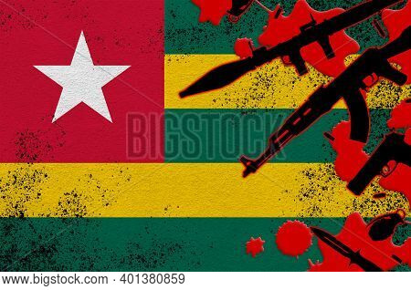 Togo Flag And Various Weapons In Red Blood. Concept For Terror Attack Or Military Operations With Le