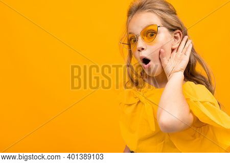Portrait Of Young Caucaian Girl With Long Fair Hair In Yellow Glasses Smiles