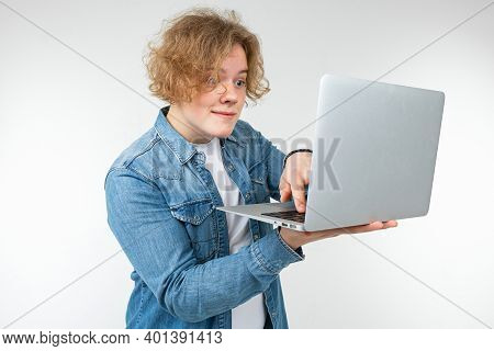 Blond Guy Is Typing On A Keyboard A Message On A Laptop On A White Background.