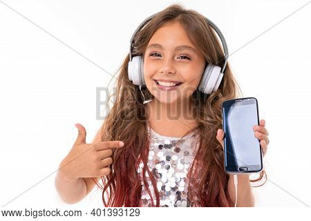 Little Pretty Caucasian Girl Listen To Music With Big Earphones And Recommed The Phone, Picture Isol