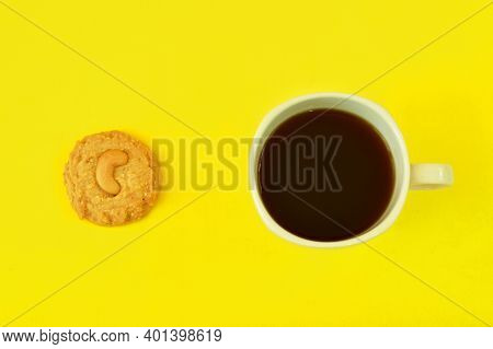 Chew Nut Cookie And Black Coffee Cup On Yellow Background