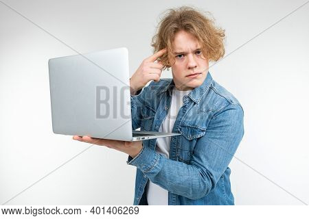 Blond Guy Prints A Message On A Laptop On A White Background.