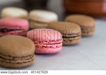 A Close Up Of Colourful Macaroons Or Macarons In A Row Focussing On A Pink Macaroon Amongst Chocolat
