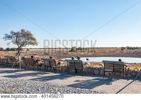 Etosha National Park, Namibia - June 12, 2012: Tourists At The Waterhole Viewpoint At Okaukeujo Rest