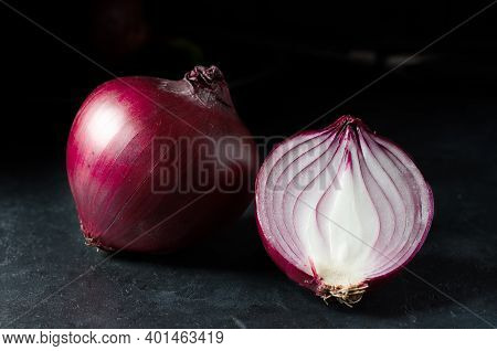 Red Onion. Large Onion And Sliced. Black Background. Side View.