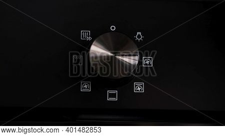 Turning The Cooktop Button On A Electrical Oven On. Concept . Close Up Of Woman Hand Turning The Han