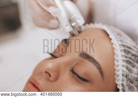 Cropped Close Up Of A Beautiful Woman Getting Facial Treatment At Beauty Clinic. Cosmetologist Using