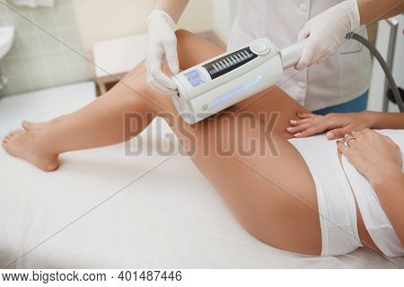 Beautician Massaging Legs Of Female Client With Endospheres Apparatus At Beauty Salon