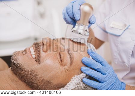 Cropped Close Up Of A Mature Handsome Man Smiling With His Eyes Closed, Getting Ultrasound Cavitatio