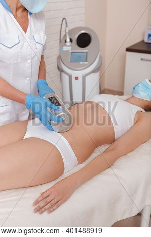 Vertical Shot Of A Woman And Beautician Wearing Protective Medical Masks During Endospheres Massage 
