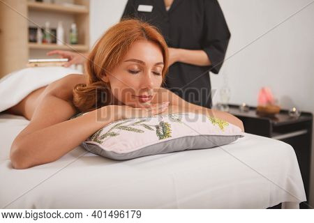 Happy Beautiful Woman Enjoying Full Bosy Massage At Spa Center. Gorgeous Woman Smiling With Eyes Clo