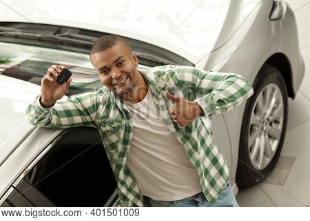 Top View Horizontal Shot Of A Happy Handsome African Man Showing Thumbs Up Holding Car Keys, Standin