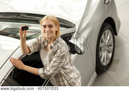 Horizontal Shot Of A Beautiful Young Happy Female Driver Smiling Holding Car Keys To Her New Automob