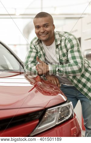 Vertical Portrait Of A Happy Handsome African Man Smiling, Showing Thumbs Up, Leaning On His New Aut
