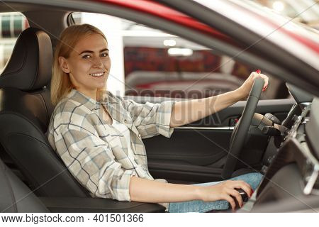 Beautiful Female Driver Smiling To The Camera Sitting In A New Automobile At The Dealership Salon. H