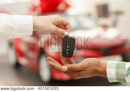 Cropped Close Up Of A Male Customer Receiving Car Keys From Salesperson After Buying New Automobile 