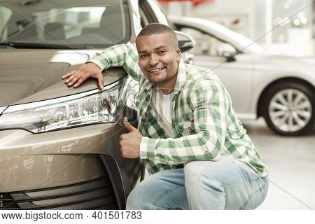 Happy African Handsome Man Smiling To The Camera Showing Thumbs Up Posing Near His New Automobile At