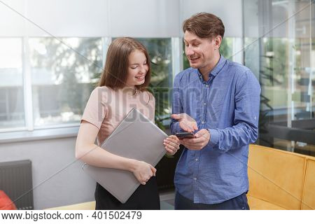 Mature Male Entrepreneur Talking To His Female Colleague At Open Space Office