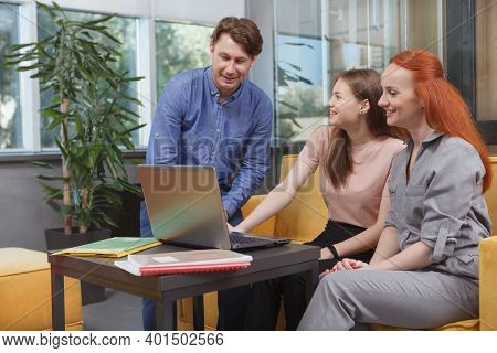 Mature Businessman Talking To His Female Colleagues At Open Space Office