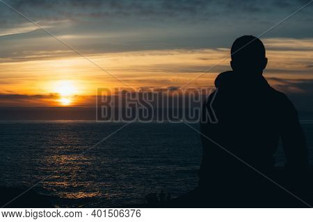 The Picture Shows A Portrait Of The Silhouette Of A Young Man Facing The Sea At Sunset. Relax Concep