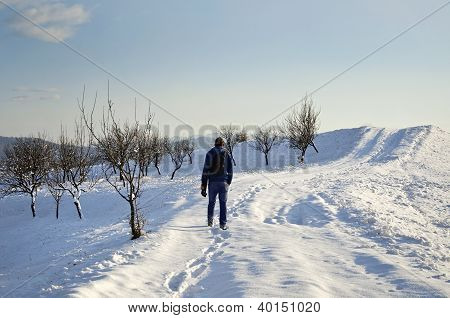 Solitary Man gå genom snön på en vinterdag