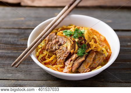 Northern Thai Food (khao Soi), Spicy Curry Noodles Soup With Beef In A Bowl And Chopsticks On Wooden