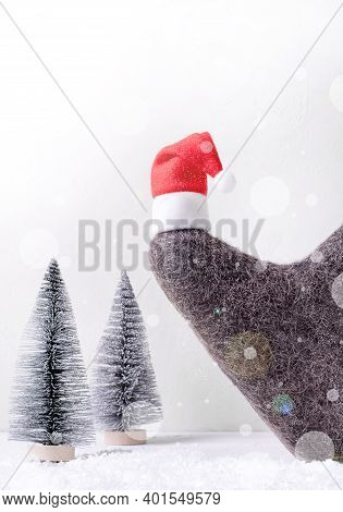 Russian Felt Boot With Small Santa Hat And Small Fir Trees In The Background. Valenki, Traditional H