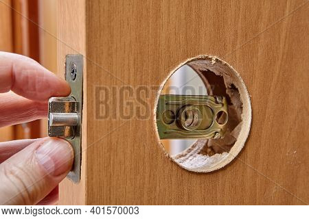 Installation  Door Knob Latch. An Carpenter Installs Round Drive-in Faceplate.