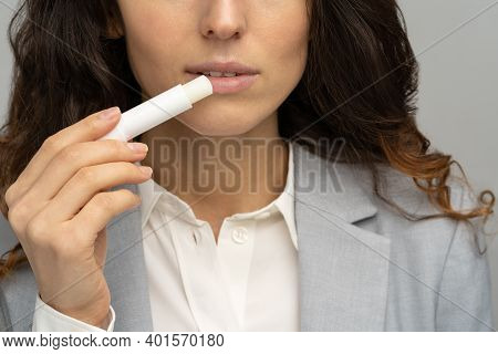 Close Up Of Business Woman Applying Hygienical Chapstick To Her Lips To Prevent Dryness And Chapping