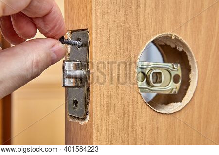 Locksmith Installs Door Knob With Lock. An Carpenter Pushes Standard Rectangular Faceplate, Slide Th