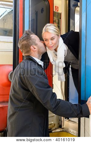 Man kissing woman goodbye on cheek train leaving friends commuter