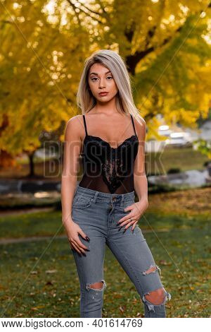 A gorgeous young blonde model poses outdoors while enjoying an autumn day