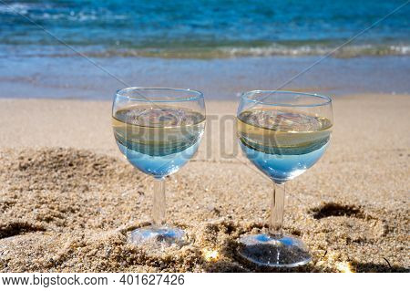 Two Glasses Of Local Dry White Wine On White Sandy Beach And Blue Mediterranean Sea On Background, N