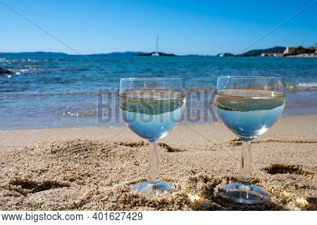 Two Glasses Of Local Dry White Wine On White Sandy Beach And Blue Mediterranean Sea On Background, N