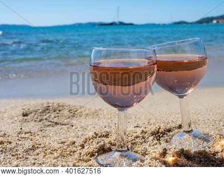 Two Glasses Of Local Rose Wine On White Sandy Beach And Blue Mediterranean Sea On Background, Near L