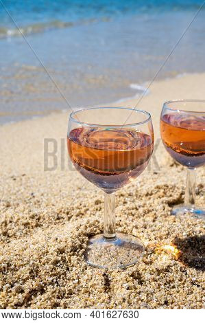Two Glasses Of Local Rose Wine On White Sandy Beach And Blue Mediterranean Sea On Background, Near L