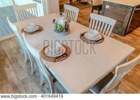Dinner Table With Tableware For Four Persons Arranged Around Candle Centerpiece